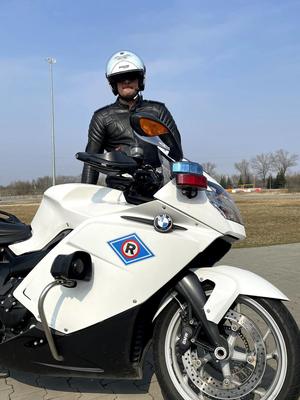 Policjant ruchu drogowego przy policyjnym motocyklu