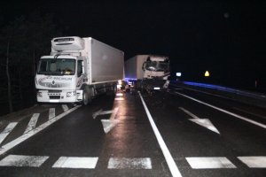 Dwa samochody ciężarowe po zderzeniu. Zdjęcie wykonane nocą.