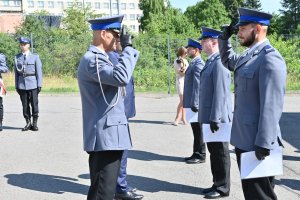 Awansowany na wyższy stopnień służbowy policjant oddaje honor komendantowi Powiatowemu Policji w Olkuszu.
