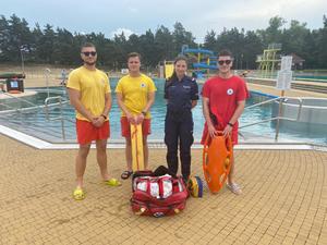 Policjantka wraz z ratownikami wodnymi przy basenie w Bukownie.