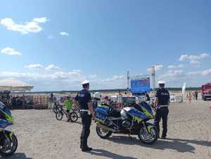 Dwaj policjanci ruchu drogowego z motocyklami  na terenie Pustyni Błędowskiej w strefie kibica.