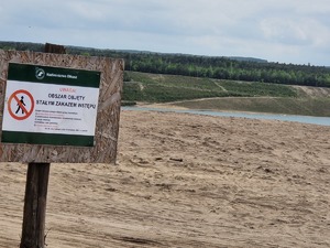 Tabliczka informująca o zakazie wstępu w tle pejzaż Pojezierza Olkuskiego