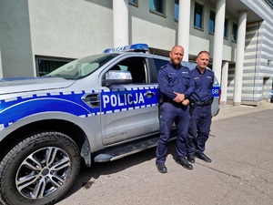 Dzielnicowi Komendy Powiatowej Policji w Olkuszu młodszy aspirant Kamil Lisowski i młodszy aspirant Wojciech Dym. W tle budynek komendy.