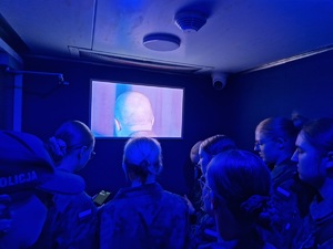 Uczniowie w pomieszczeniu Escape trucka przed monitorem. W pomieszczeniu przyciemnione światła.