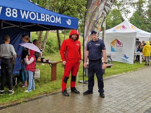 Komendant Komisariatu w Wolbromiu wraz ze strażakiem z OSP w Chrząsowicach przy stanowisku profilaktycznym. W tle namioty instytucji.