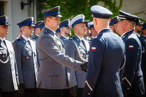 Komendant Wojewódzki gratuluje awansowanemu policjantowi (uścisk dłoni) .