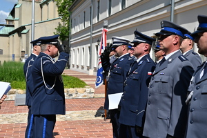 Policjant ruchu drogowego w galowym mundurze oddaje honor komendantowi wojewódzkiemu policji