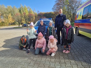 Policjantka z dziećmi  przy radiowozie