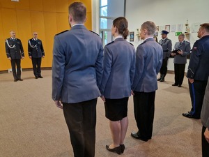 komendanci, mianowani i uczestnicy ceremonii w galowych ubraniach. Policjanci stoją na baczność w równym szyku.