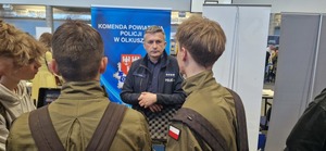 Uczniowie w mundurach przy policjancie ruchu drogowego