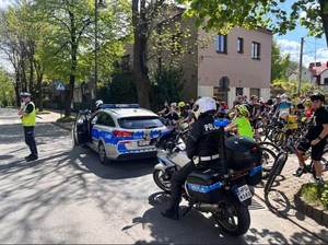 Policjant ruchu drogowego podczas zabezpieczenia przejazdu peletonu kieruje ruchem