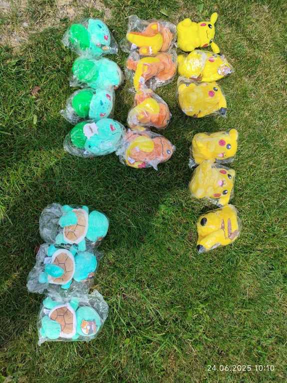 Pluszowe zabawki typu pokemon leżące na trawie