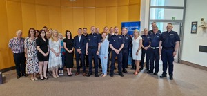 Pracownicy cywilni i policjanci na wspólnym zdjęciu z odchodzącym na emeryturę policjantem