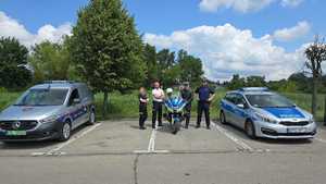 policjanci i strażnicy miejscy pomiędzy radiowozami.
