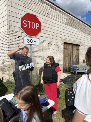 Policjant pokazujący kobiecie sprzęt policyjny.