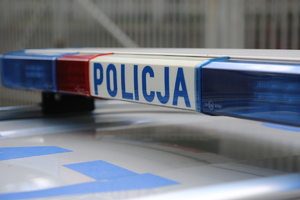 Sygnalizatory dźwiękowo-świetlne z napisem &quot;Policja&quot; na dachu radiowozu.