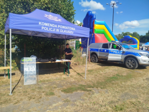 Stanowisko profilaktyczne Policji. W tle radiowóz.