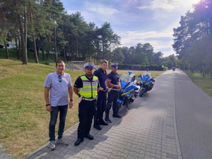 Radny p. Kamil Czopek wraz z policjantami KPP Olkusz. W tle motocykle policyjne.