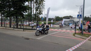 Policjat na motocyklu zabezpieczający bieg. W tle uczestnicy.