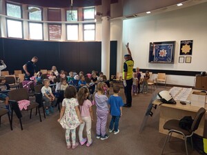 Dzieci podczas prelekcji prowadzonej przez policjanta ruchu drogowego.