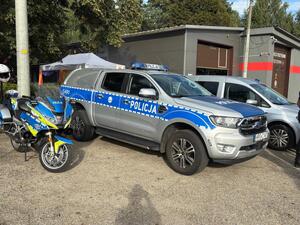 Policyjny motocykl i radiowozy.