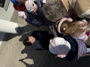 Dzieci wręczające laurkę policjantce.