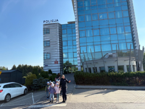 Dzieci przeprowadzane przez policjantkę przez pasy.
