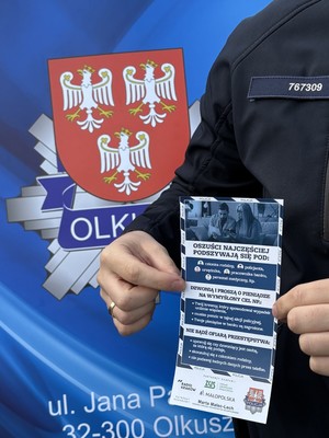 Policjant z ulotką dla seniorów.