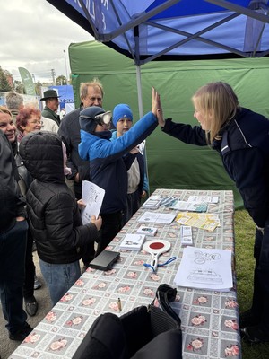 Policjantka przybija piątkę z uczestnikiem wydarzenia przy stanowisku profilaktycznym.