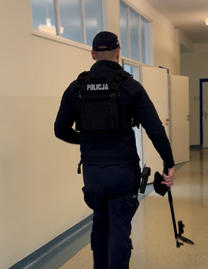 Policjant sprawdzający budynek szkoły.