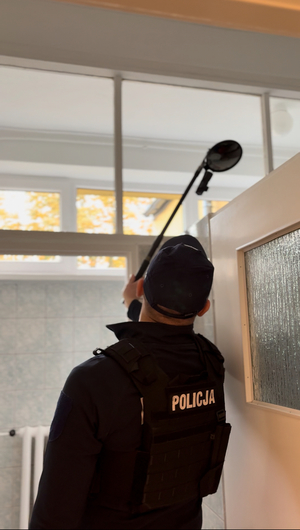 Policjant sprawdzający budynek szkoły.