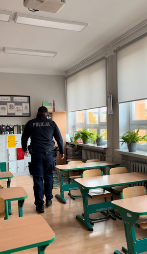 Policjant sprawdzający budynek szkoły.