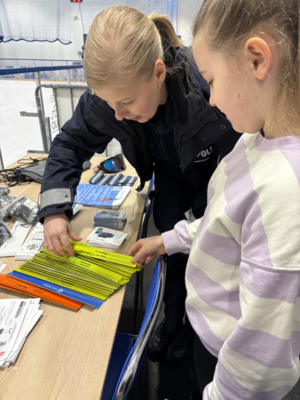 Policjantka z dzieckiem przy stanowisku profilaktycznym.