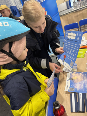 Policjantka z dzieckiem przy stanowisku profilaktycznym.