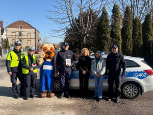 policjanci wraz z uczestnikami na tle radiowozu