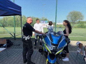 Policjant z dzieckiem na motocyklu.