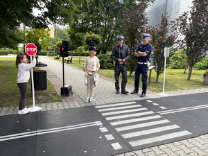 Policjanci z Wydziału Ruchu Drogowego wraz z dziećmi na mobilnym miasteczku ruchu drogowego