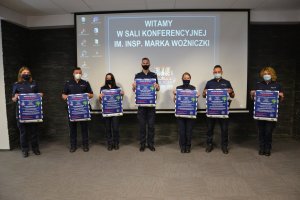 siedmioro policjantów trzyma plakaty informujące o akcji