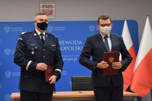 Komendant Wojewódzki Policji i Wojewoda Małopolski trzymają podpisane porozumienia.