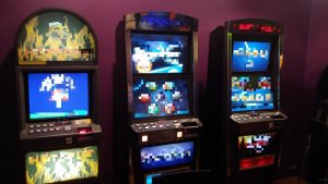 Trzy automaty przeznaczone do gier hazardowych. Urządzenia podłączone do prądu aktywne, znajdują się przy ścianie w lokalu w jednym z pomieszczeń.