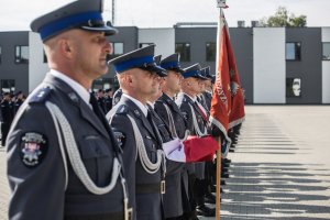 Funkcjonariusze kompanii honorowej stoją w równym szyku. Widać poczet sztandarowy.