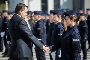 Wojewoda Małopolski wita się z policjantką.