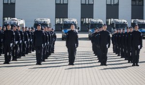 Policjanci stoją w równym szyku.