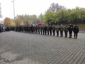 Uczniowie w mundurach stoją w szeregu przed budynkiem MOSiR w Olkuszu.