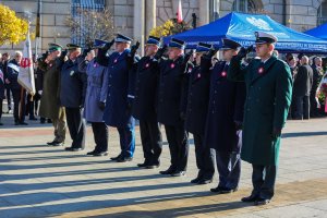 Komendant Wojewódzki Policji oraz przedstawiciele służb mundurowych oddają honory.