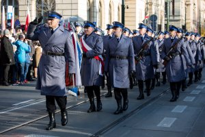 Pokaz musztry paradnej Policji ulicami Krakowa. Wokół gromadzą się uczestnicy.