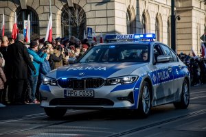 Policyjny radiowóz podczas przejazdu z okazji Święta Niepodległości.