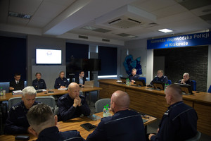 Na zdjęciu widoczni policjanci uczestniczący w odprawie  siedzący przy stołach w umundurowaniu słuzbowym  (2)