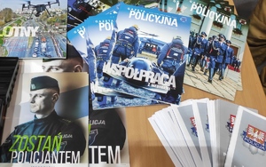 Na stanowisku promocyjnym policji „Targi Pracy 2023” leżą gazety policyjne w tym gazeta z napisem „Zostań policjantem”.