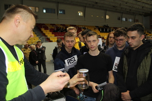 technik kryminalistyki w odblaskowej kamizelce zabezpiecza ślady odcisków linii papilarnych na słoiku